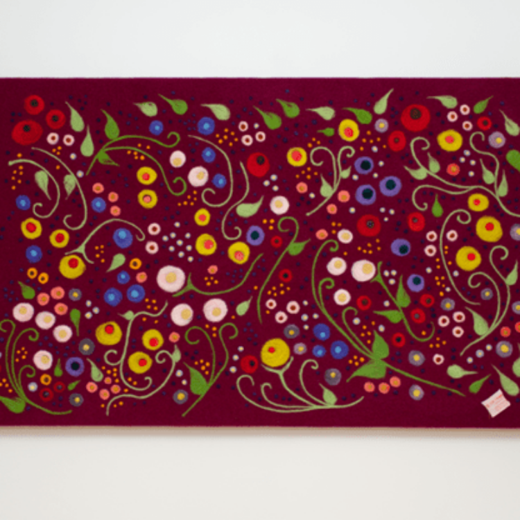 Felted flowers in whimsical and swirly patterns on a large canvas.