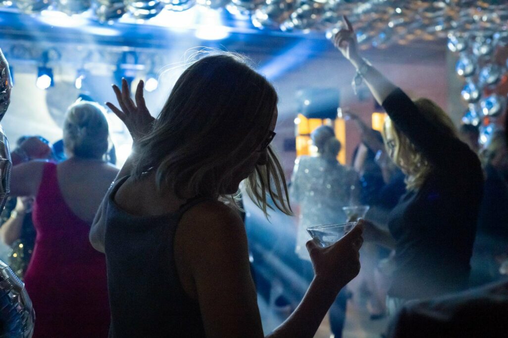 Silhouettes of people on a dance floor with bright blue lights.